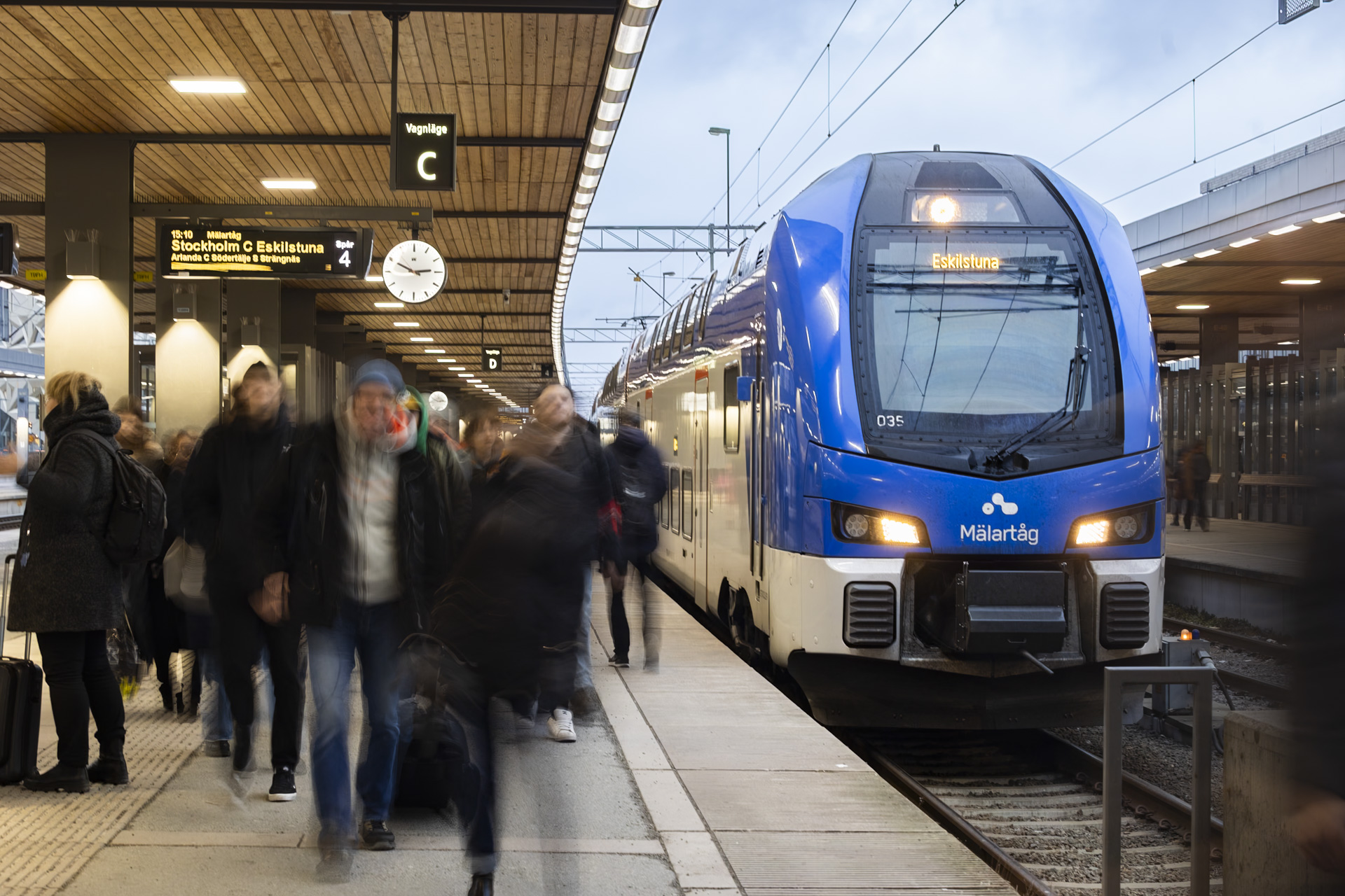 Mälartåg vid perrongen i Uppsala med resenärer i rörelse utanför