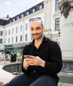 Person som använder sin mobil utanför centralstaionen i Stockholm
