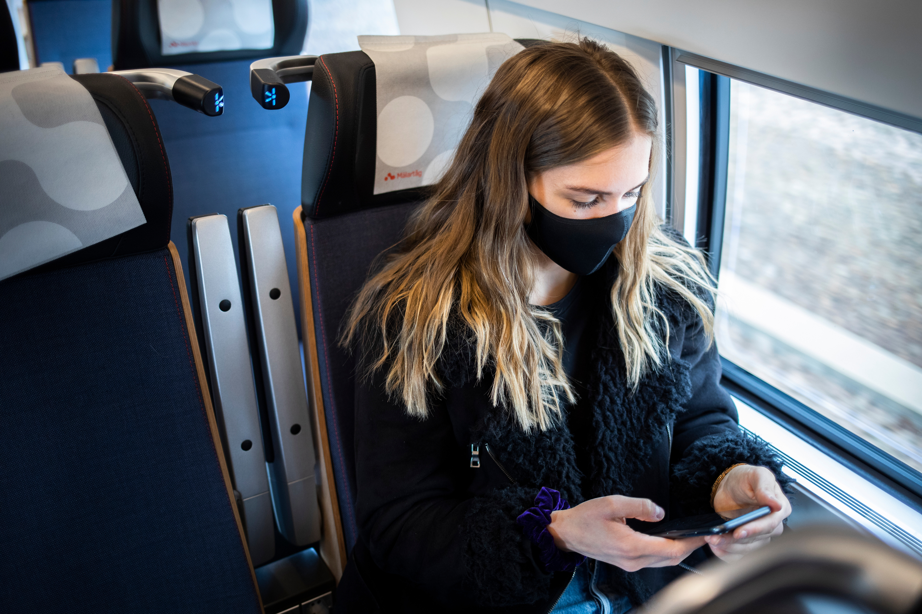 Tjej med munskydd på tåget