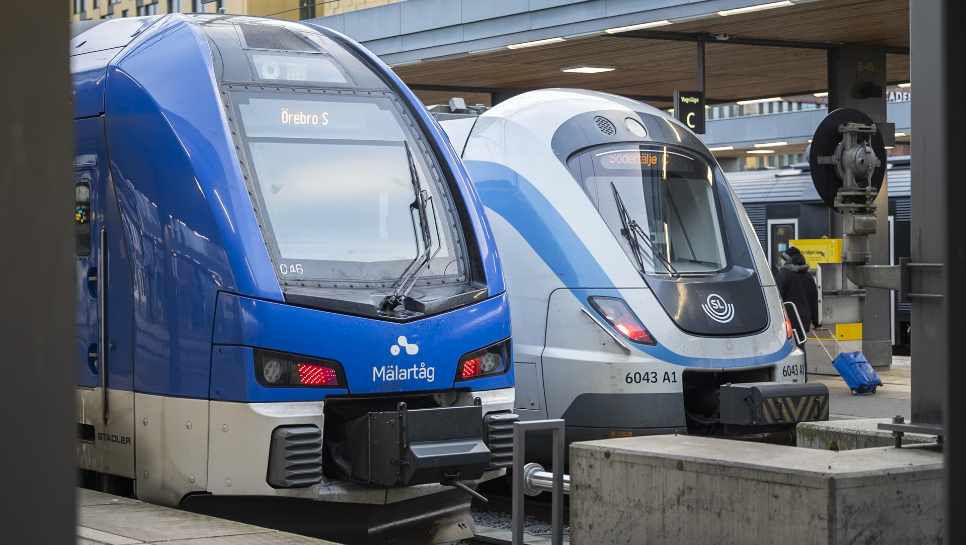 Ett Mälartåg och SL pendeltåg vid plattformen i Uppsala