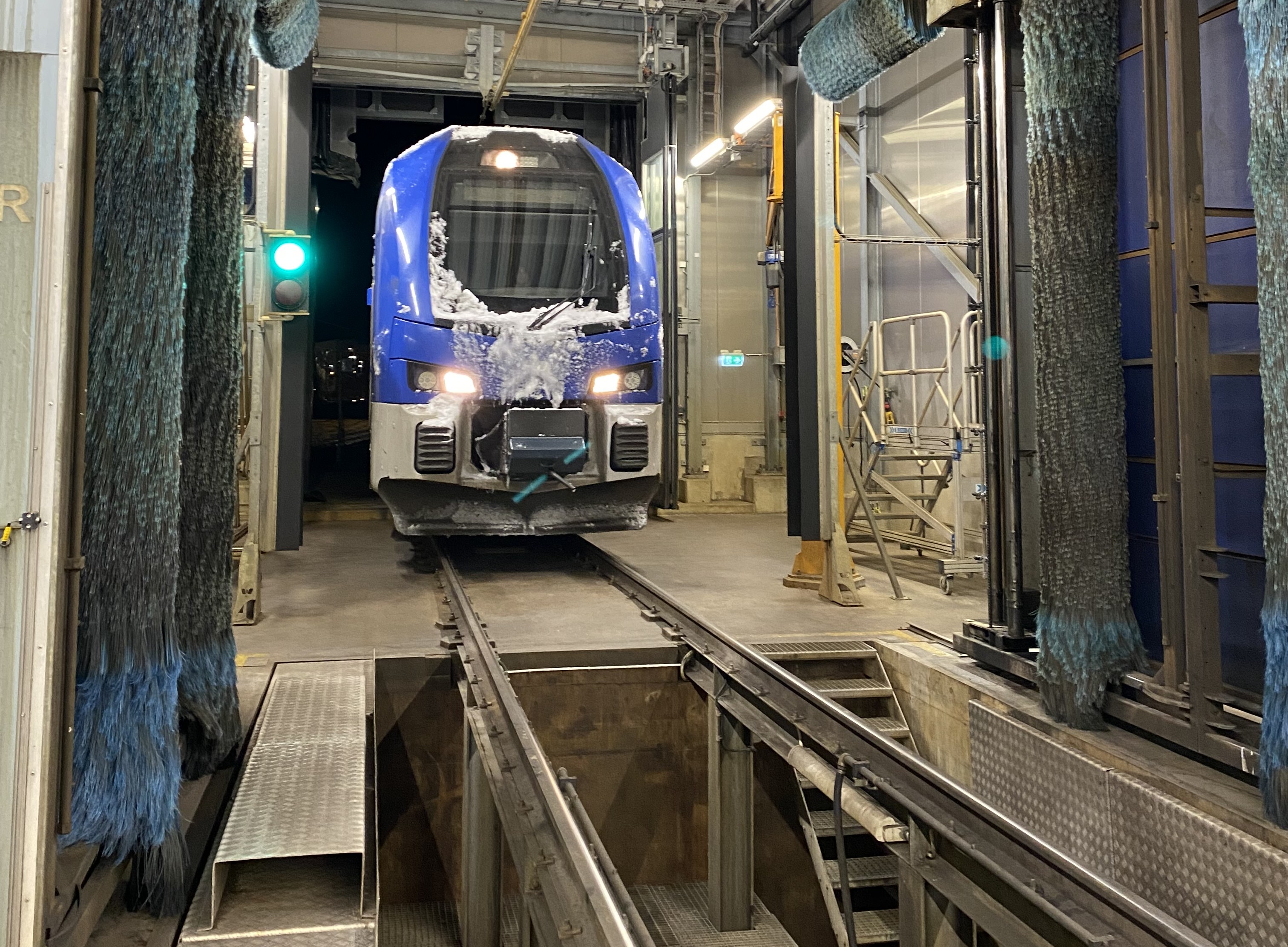 Ett Mälartåg rullar in i avisningshallen i depån.