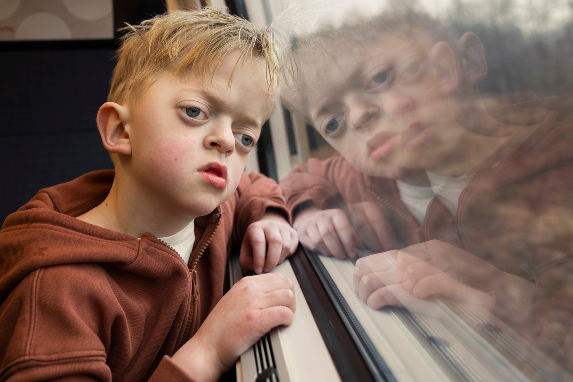 Ett barn tittar ut genom fönstret på tåget