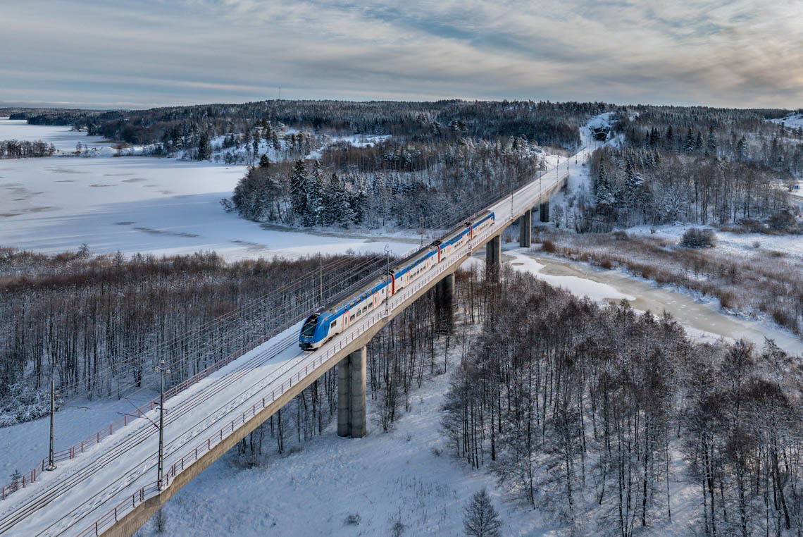 Tåg på bro i vinterlandskap