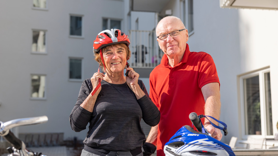 En man och en kvinna står bredvid sina cyklar med sina hjälmar