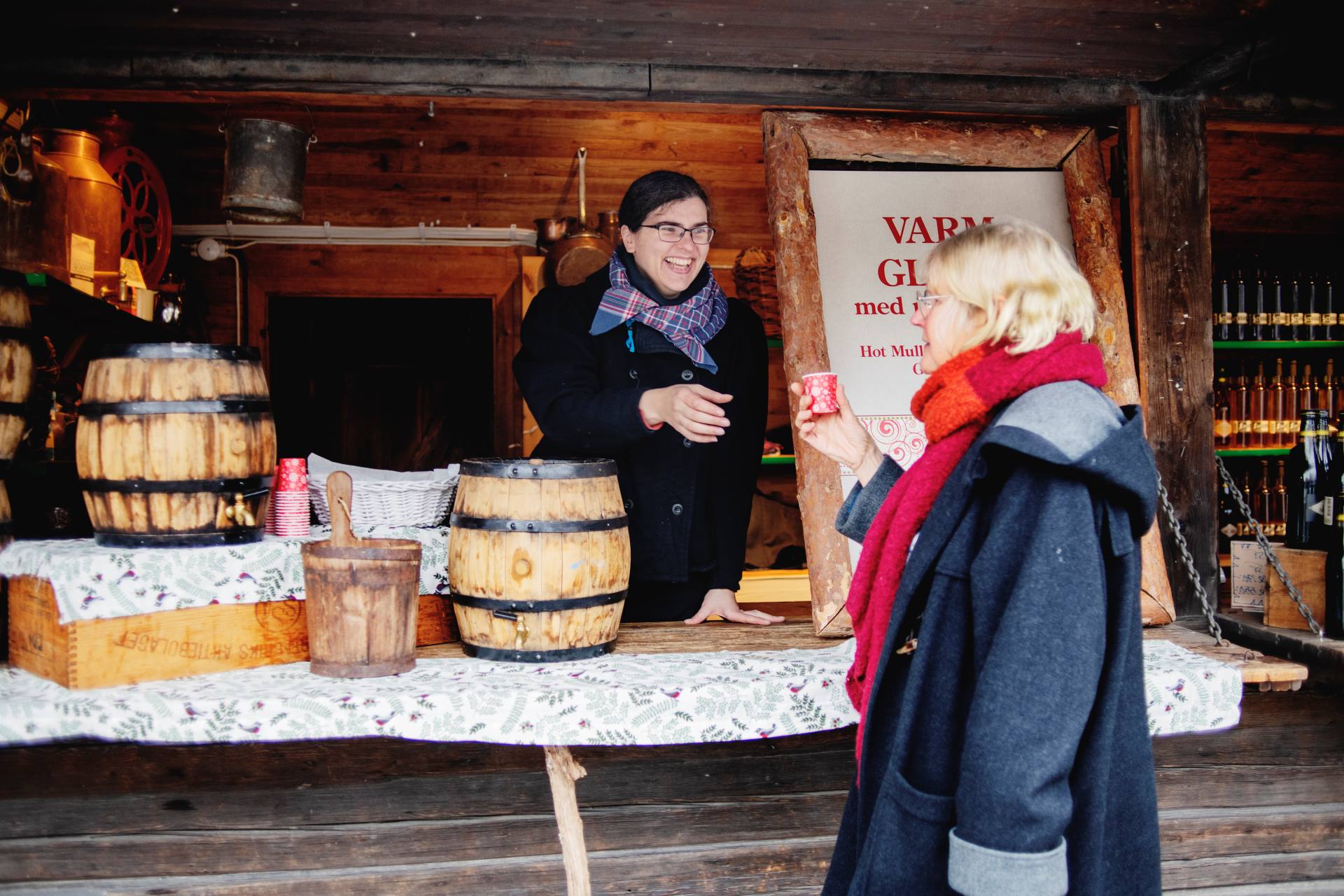 En kvinna serverar glögg i ett stånd på Skansens julmarknad. 