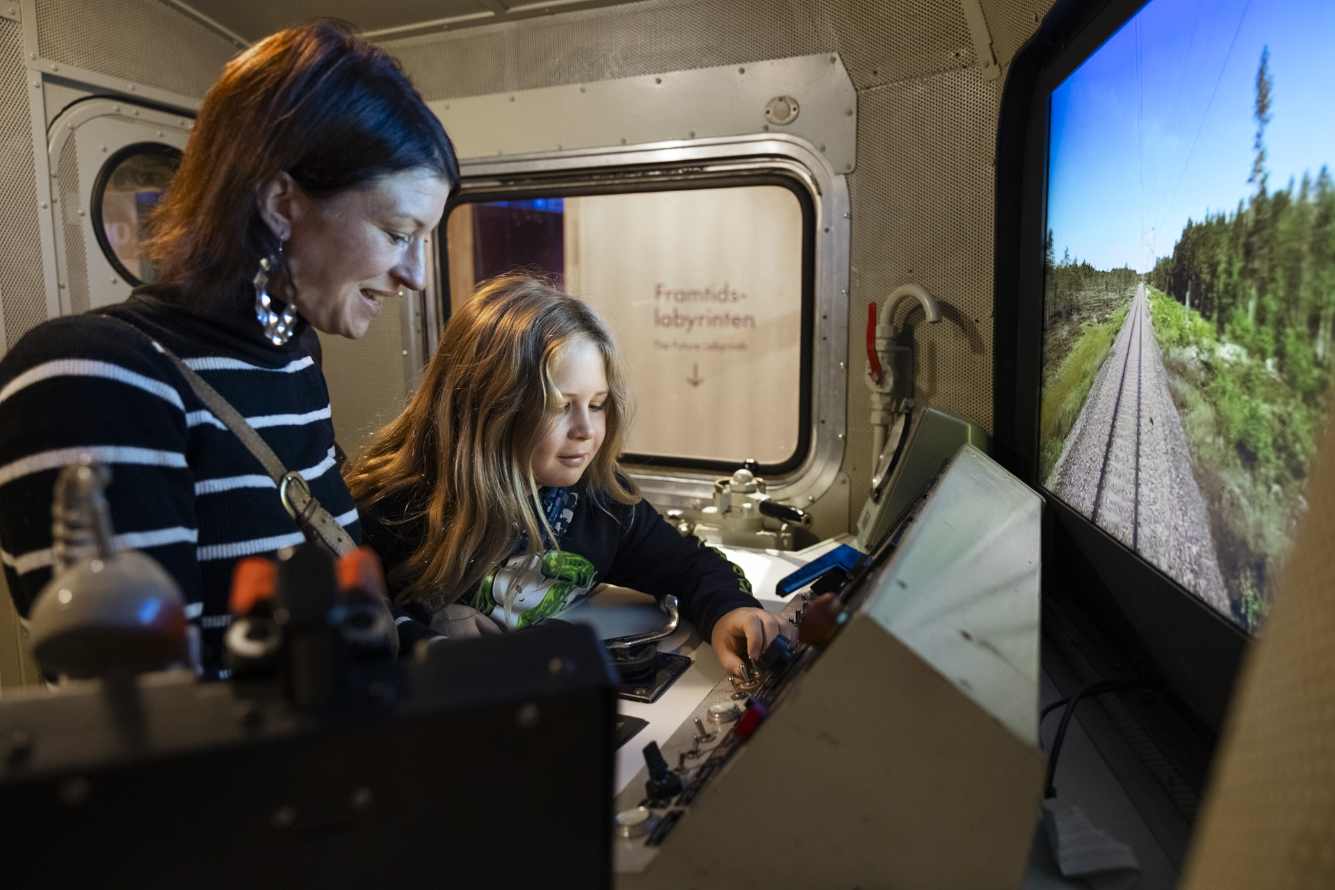 kvinna och pojke vid lokförarsimulator