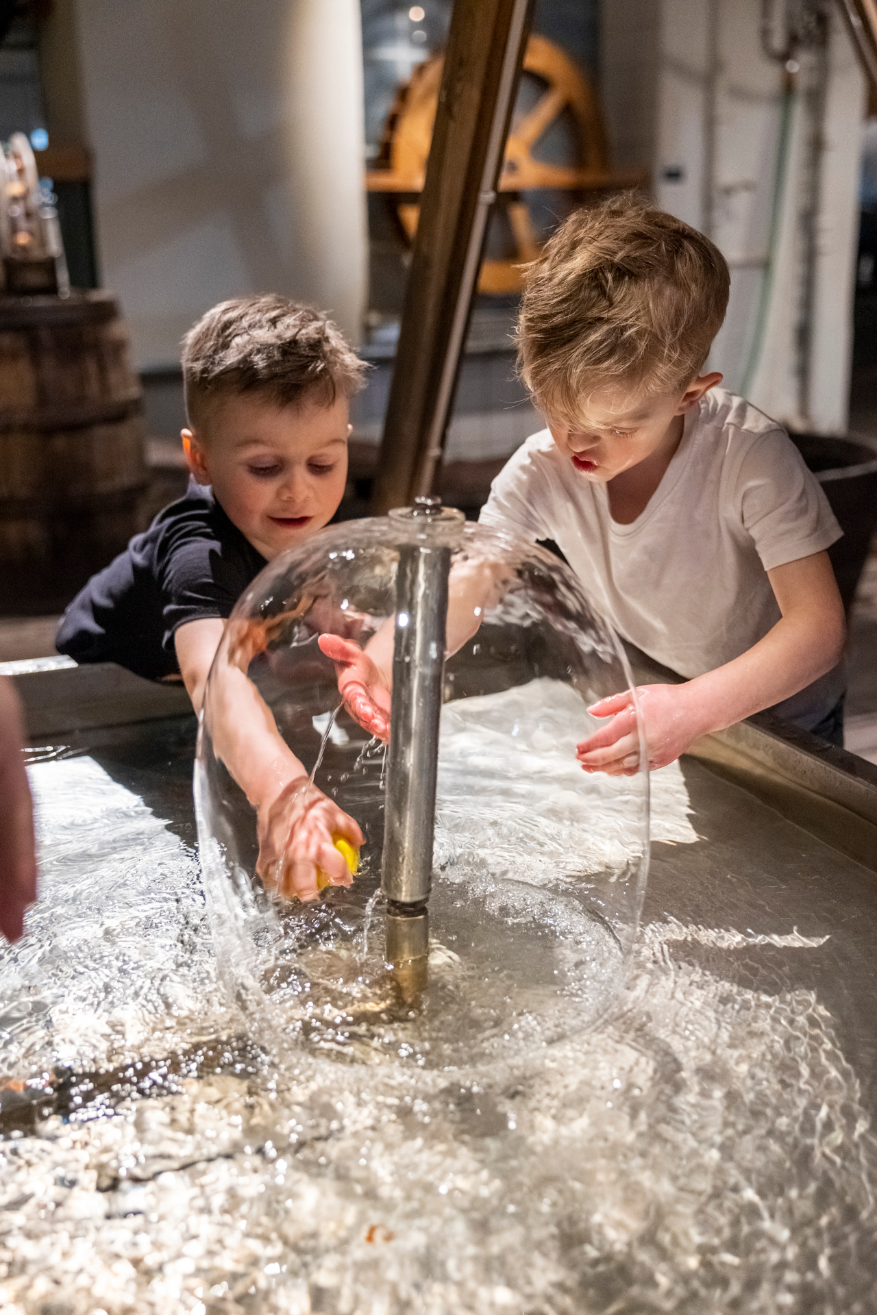 två barn leker med en fontän på tom tits